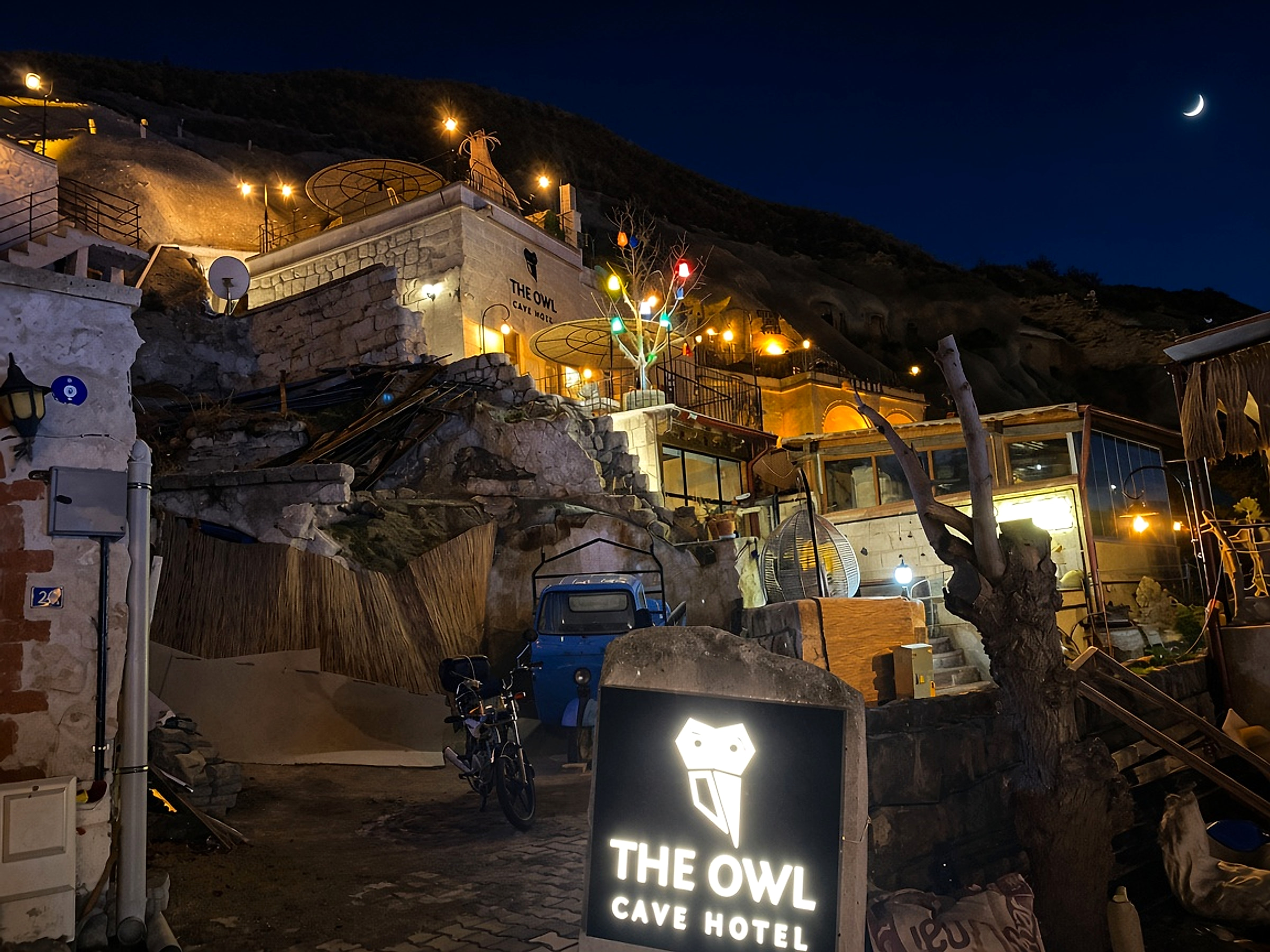 Night entrance to The Owl Cave Hotel in Göreme, Cappadocia, with the hotel sign under the stars
