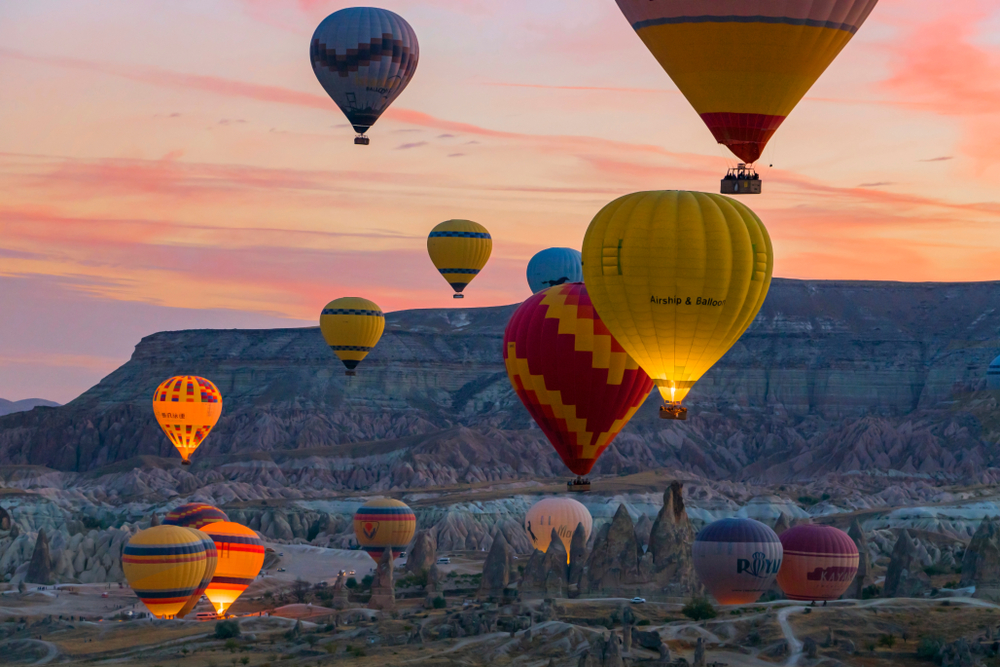 Hot air balloons over Cappadocia valleys at sunrise on the bookable Göreme Sunrise Balloon Flight from The Owl Cave Hotel