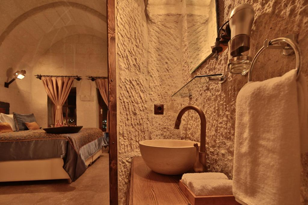 Stone sink looking through to the Deluxe Arch Room with View bedroom at The Owl Cave Hotel in Göreme