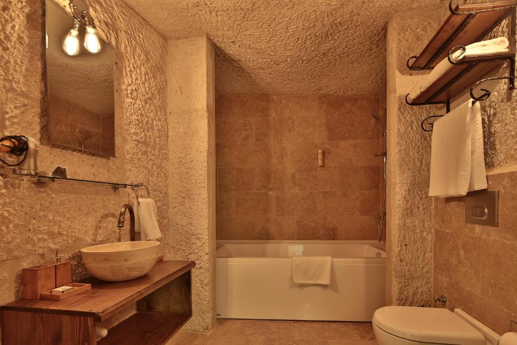 Private bathroom with bath and shower in the Deluxe King Suite at The Owl Cave Hotel, Göreme, Cappadocia