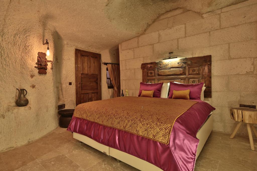 Bookable Premier Cave Room king bed in a volcanic tuff cave at The Owl Cave Hotel, Göreme, Cappadocia